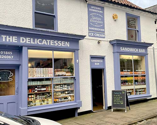 Upstairs Downstairs is a tearooms, delicatessen and sandwich bar overlooking the market place in Thirsk